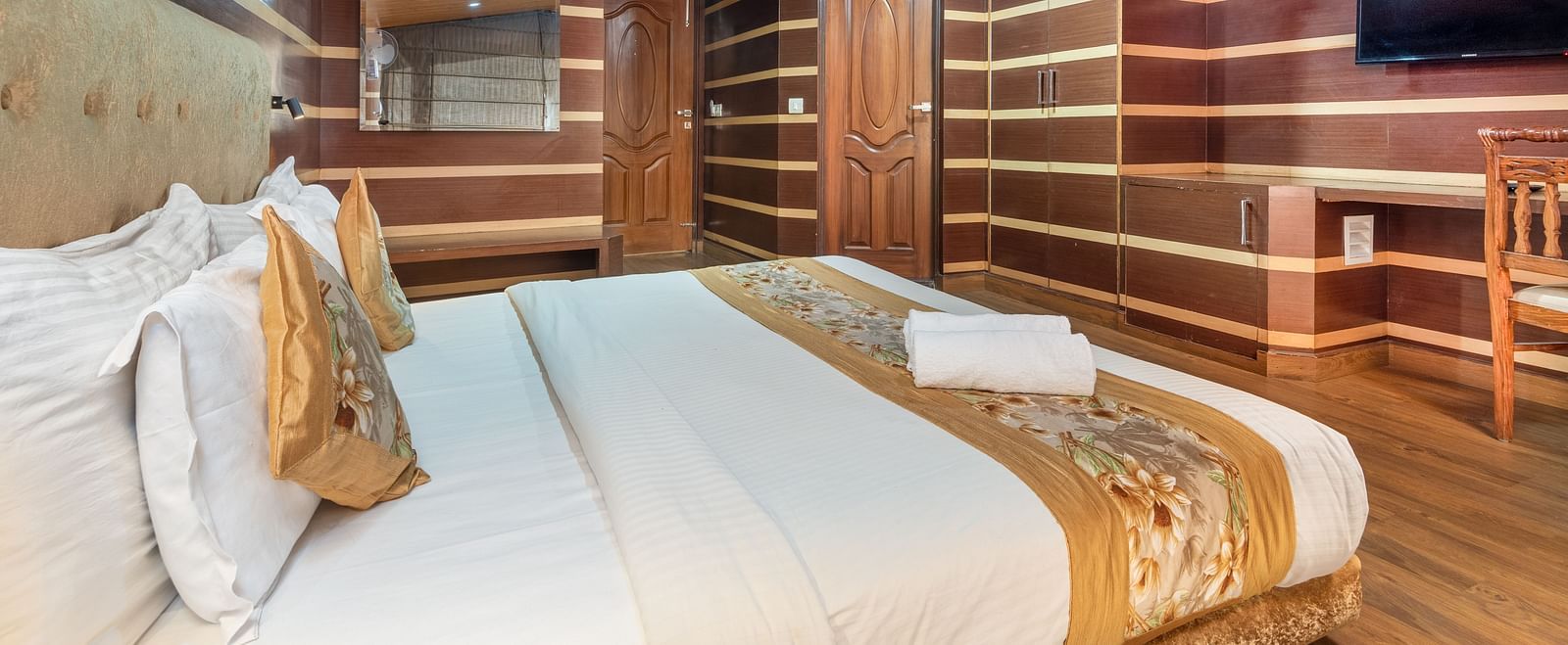 Super deluxe room featuring a king size bed and a wall-mounted TV at DLS Hotels The Rock Castle.